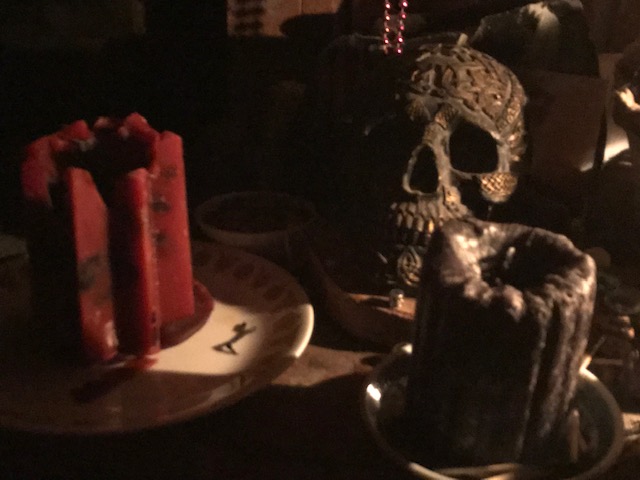 Altar with patterned resin skull and red and black candles